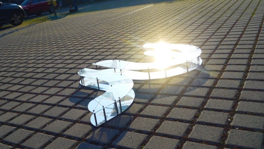 Logo NetzReporter im Sonnenlicht auf Parkplatz der Hochschule Rhein-Main